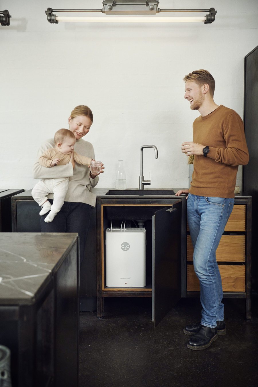 Famille dans sa cuisine buvant l'eau purifiée par l'A2O Pure